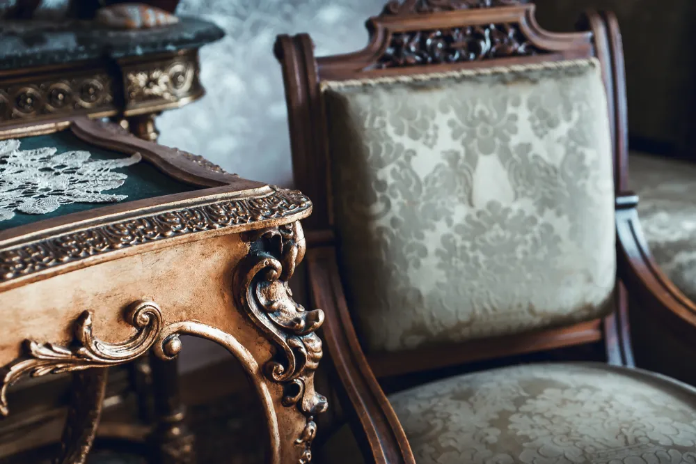 A vintage wooden table and upholstered mahogany chair